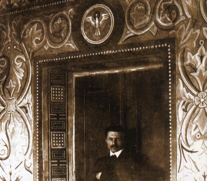 Михайло Бойчук на тлі розписів входу до каплиці Дяківської бурси у Львові. 1913 р.